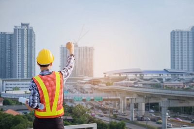 工程師或建筑師與防護安全帽檢查建筑圖紙呼叫支持團隊在建筑工地。工程建筑和建筑施工理念。軟焦點